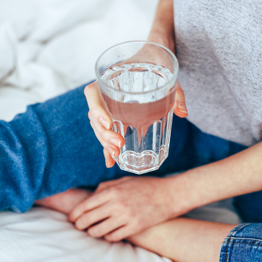 Hands holding a glass of water